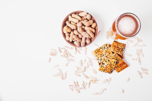 Nueces y galletas con cerveza en blanco.