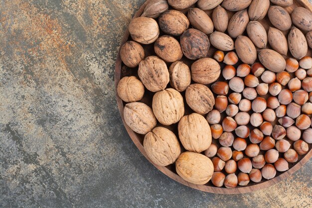 Nueces marrones mixtas nutritivas en cuenco de madera. Foto de alta calidad