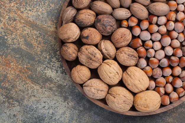 Nueces marrones mixtas nutritivas en cuenco de madera. Foto de alta calidad