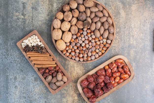 Nueces mixtas con canela y frutos secos en placa de madera. Foto de alta calidad