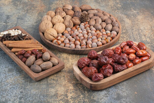Nueces mixtas con canela y frutos secos en placa de madera. Foto de alta calidad