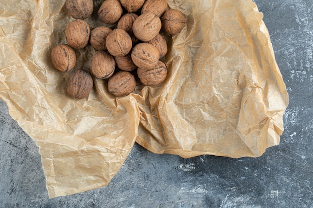 Nueces orgánicas en hoja de papel marrón.