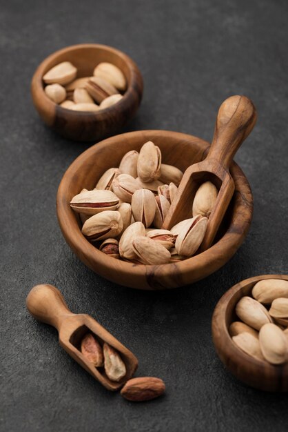 Nueces de pistacho en cuencos de madera con cucharas