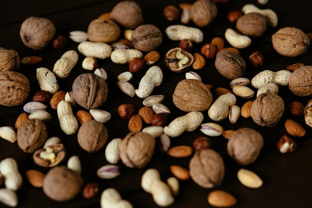 Nueces. Pistacho, nuez, avellana y maní. Mezcla de frutos secos sobre fondo negro