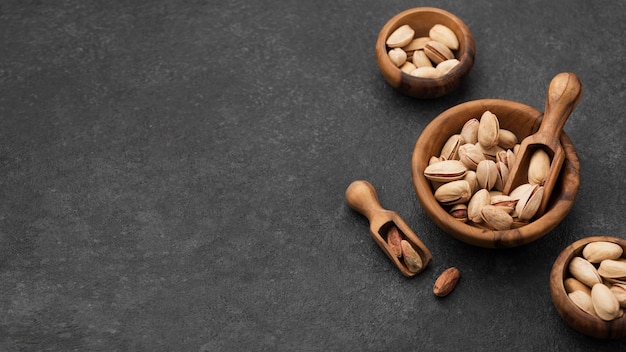 Nueces de pistacho en tazones con espacio de copia de cucharas de madera