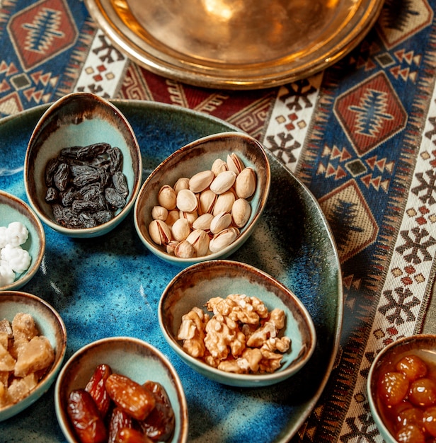 Foto gratuita nueces pistachos caquis pasas pasas en tazones