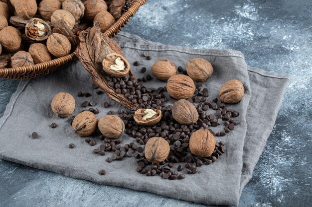 Nueces saludables con aroma de granos de café sobre un mantel gris.