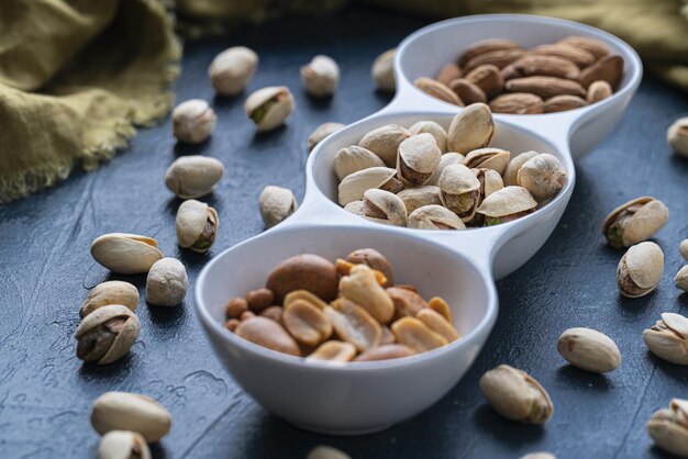 Nueces tostadas y pistachos salados en un tazón de cerámica blanca