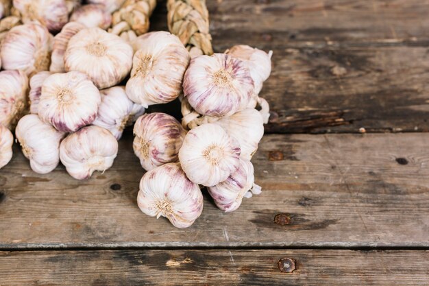 Nueva cosecha gran ajo violeta trenza sobre fondo de madera