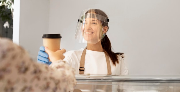 Nueva normalidad en la cafetería con protector facial