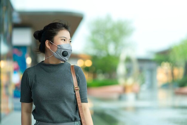 Nueva normalidad después de la epidemia de covid, empresa joven, mujer asiática, usa máscara de protección facial caminando en el centro de la plaza, grandes almacenes, centro comercial, nuevo estilo de vida después de la propagación del virus corona covid19