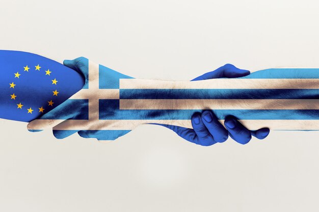 Nuevas oportunidades. Manos masculinas sosteniendo la bandera de color azul de la UE y Grecia aislada sobre fondo gris de estudio. Concepto de ayuda, mancomunidad, asociación de países, relaciones políticas y económicas.