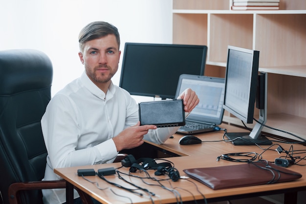 Nuevo equipamiento. El examinador de polígrafo trabaja en la oficina con su detector de mentiras