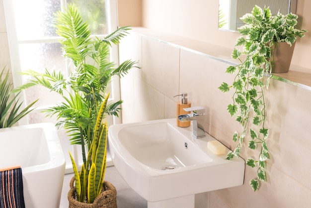 Nuevo y moderno grifo de acero con lavabo de cerámica en el baño.