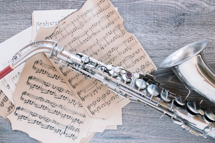 Foto gratuito nuevo saxofón en partituras
