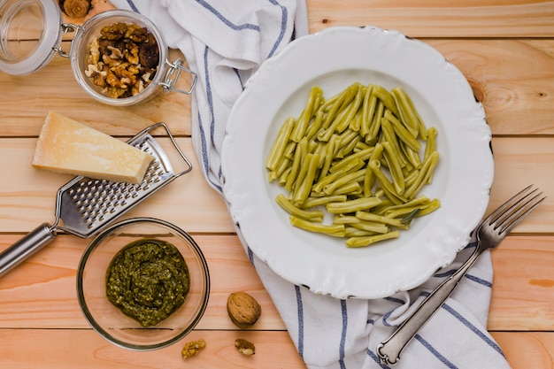 Nuez; queso; Pasta y salsa de gemelli de espinaca en mesa de madera