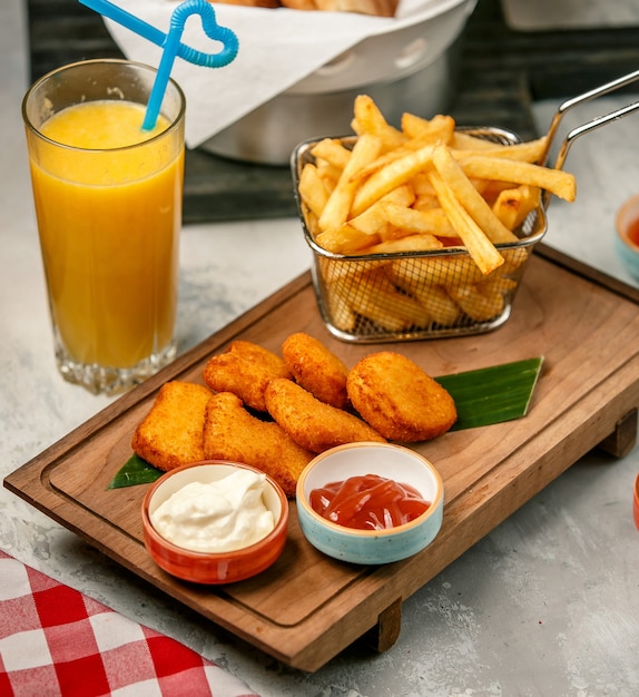 Foto gratuita nuggets fritos y papas fritas sobre tabla de madera