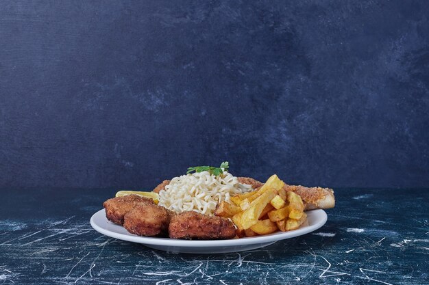 Nuggets con patatas fritas y fideos.