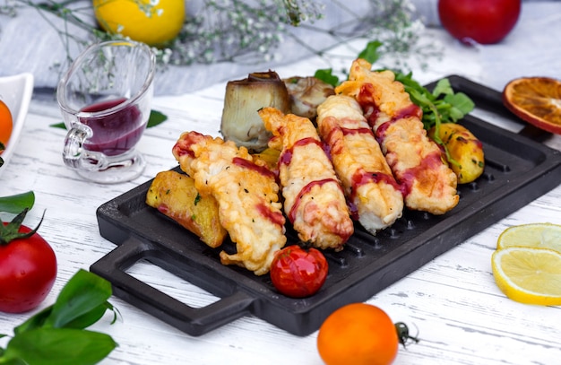 Nuggets de pescado crujientes servidos con potaot, salsa de granada y berenjena frita