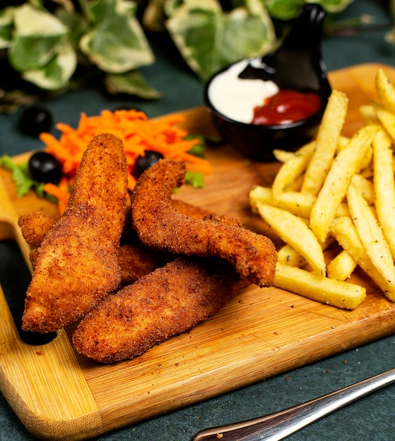 Nuggets de pollo al estilo kfc con papas fritas, mayonesa, ketchup y ensalada de verduras