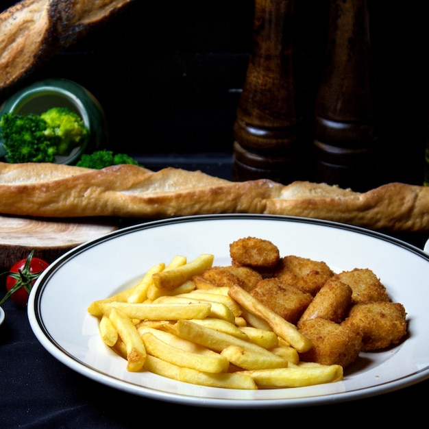 Foto gratuita nuggets de pollo crujientes con papas fritas