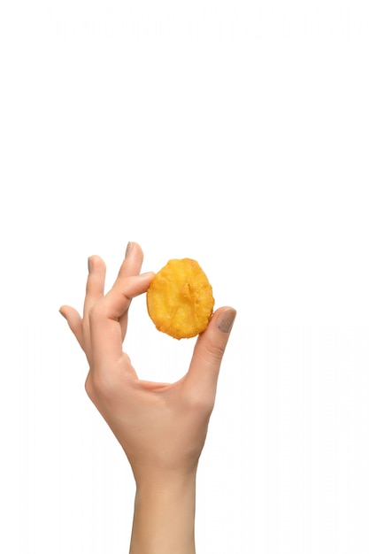 Nuggets de pollo frito en mano femenina sobre fondo blanco.