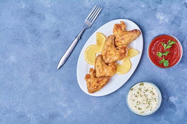 Nuggets de pollo fritos y servidos con salsas.