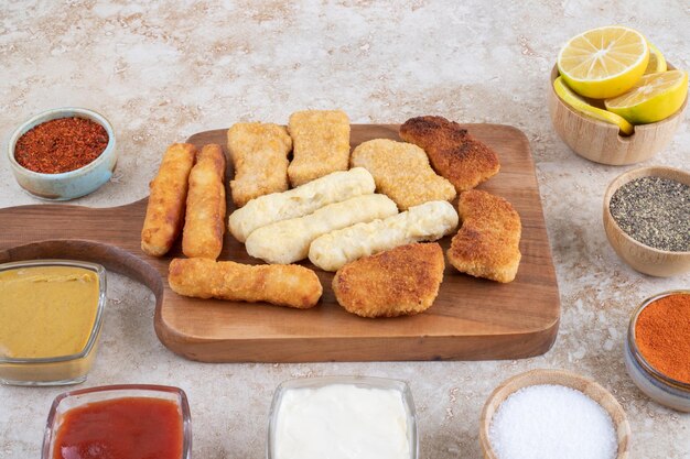 Nuggets de pollo, palitos de queso y salchichas fritas con variedad de salsas y especias.