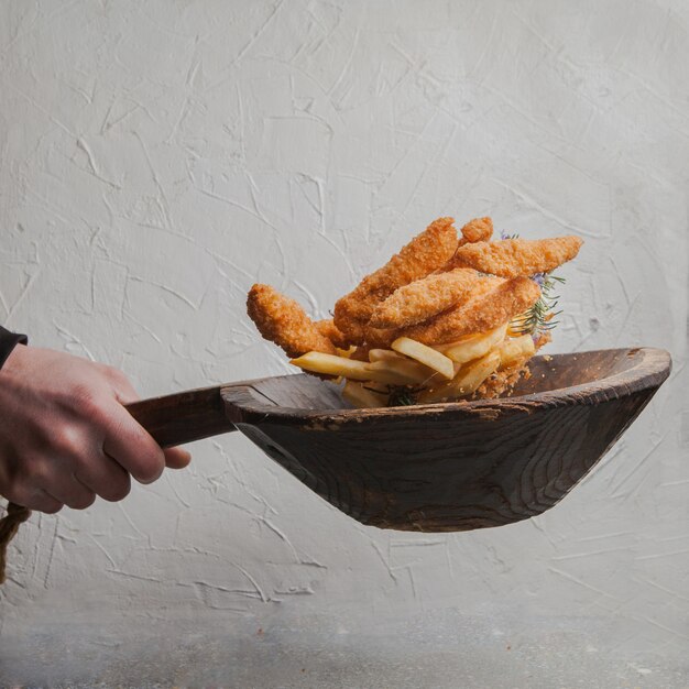 nuggets de pollo con papas fritas y mano humana en mosca