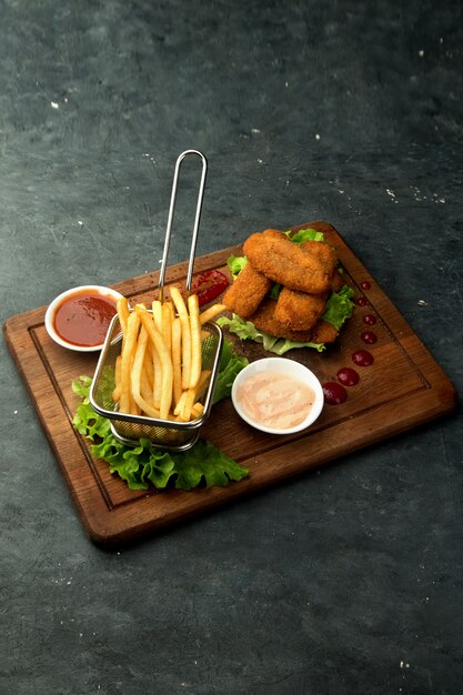 Nuggets de pollo con papas fritas y salsas