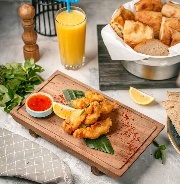 nuggets de pollo con salsa sobre tabla de madera