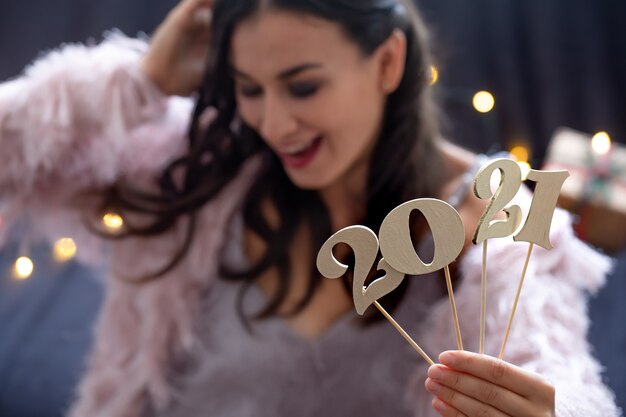 Número de año nuevo de madera en el fondo de una niña de cara feliz de cerca.