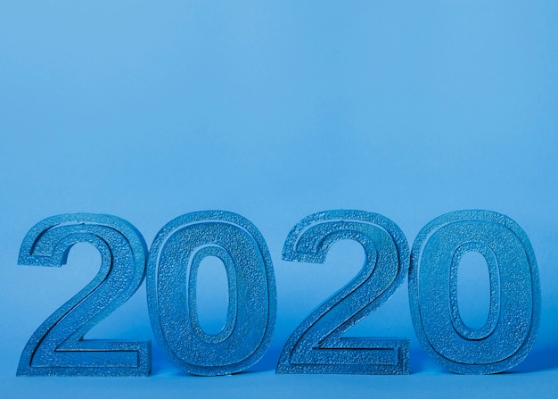 Números de año nuevo 2020 sobre fondo azul con espacio de copia