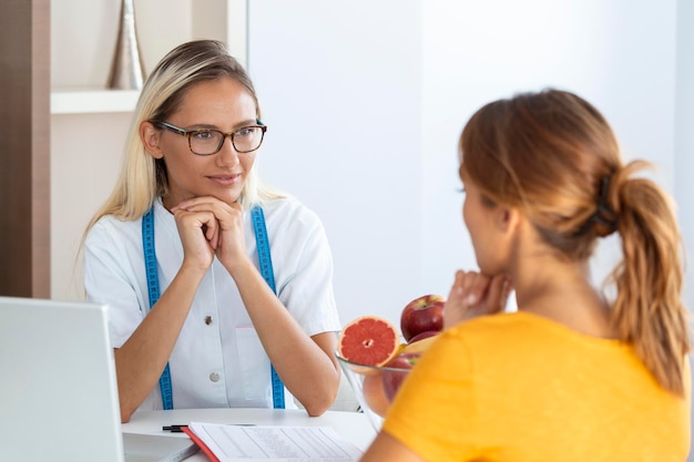 Foto gratuita nutricionista femenina dando consulta al paciente elaboración de un plan de dieta en la clínica de pérdida de peso