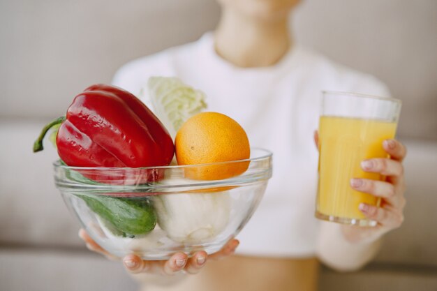 Nutricionista mostrando jugo y tazón de verduras