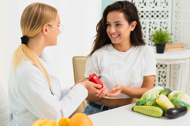 Nutricionista de tiro medio discutiendo con el paciente