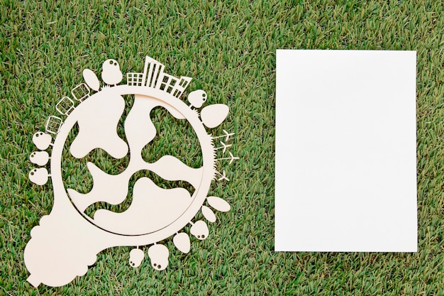Objeto de madera del día mundial del medio ambiente con tarjeta vacía sobre hierba