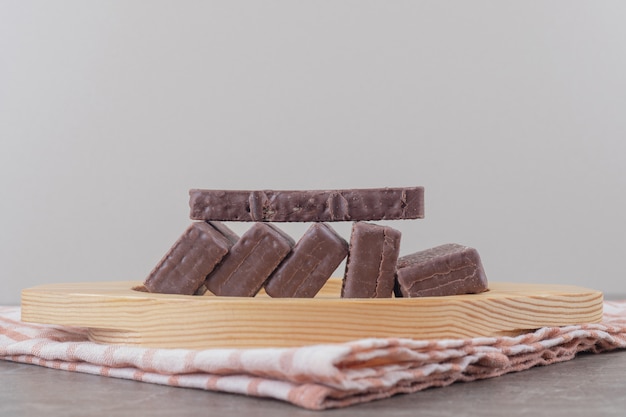 Foto gratuita obleas recubiertas de chocolate en una bandeja de madera sobre mármol