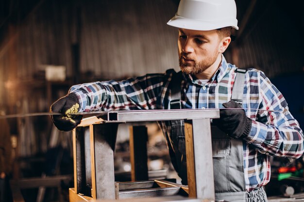 Obrero vistiendo har hat con regla de medición en la fábrica.