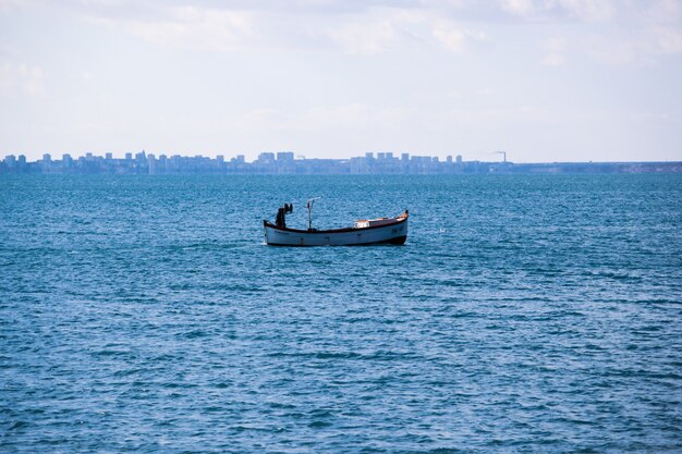 Océano tranquilo con un barco bajo un cielo nublado