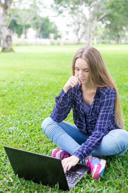 Ocupado estudiante usando la computadora portátil mientras prepara la investigación