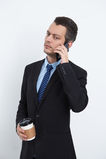 Ocupado gerente beber café y hablar por teléfono