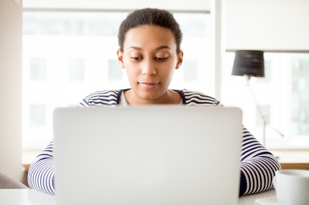 Ocupado mujer usando la computadora portátil en casa