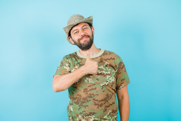 Foto gratuita el oficial sonriente muestra un gesto perfecto en el fondo azul