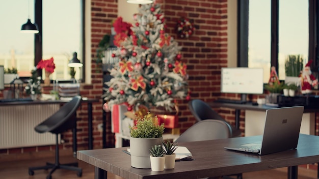 Oficina de negocios decorada con árbol de navidad y luces para celebrar la festividad navideña durante la temporada de invierno. Espacio vacío lleno de adornos y adornos navideños, tradición estacional.