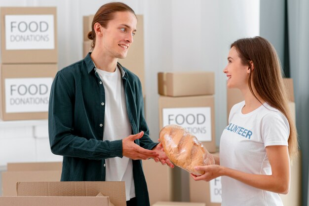 Ofrézcase como voluntario para la donación de alimentos entregando pan a personas necesitadas