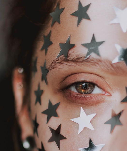 ojo hermoso femenino con estrellas plateadas en su rostro