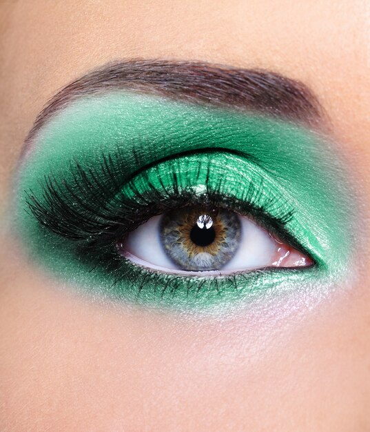 Ojo de mujer con sombras de ojos verdes - maquillaje de moda