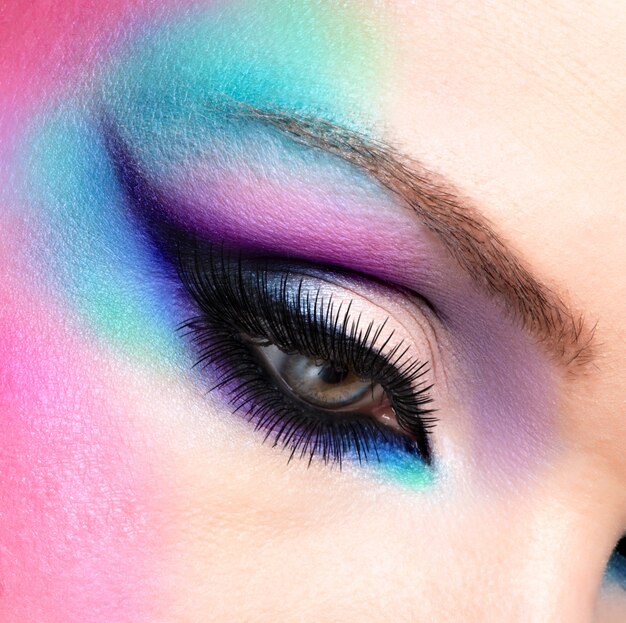 Ojos de mujer de primer plano con maquillaje azul brillante de moda hermosa