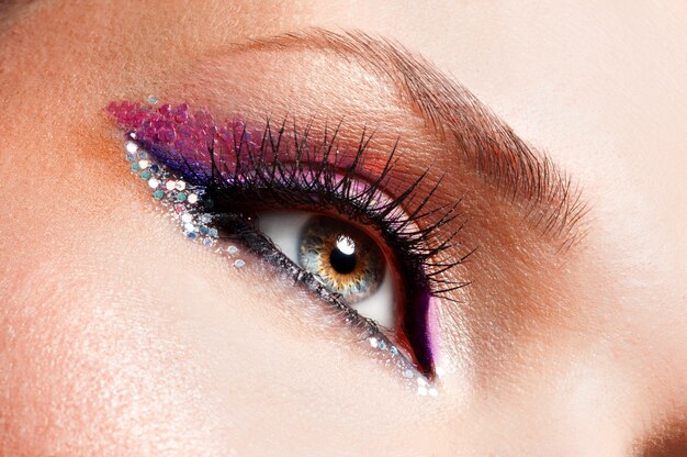 Ojos de mujer de primer plano con maquillaje rosa brillante de moda hermosa